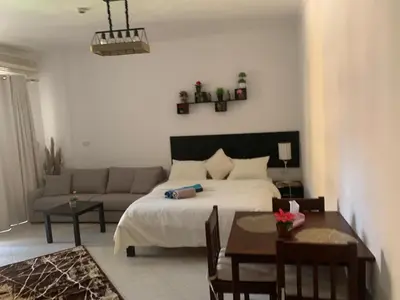 a bedroom with a bed and a couch and a table at وحدة فندقية سياحية بكمبوانداند وسط الغردقة in Hurghada