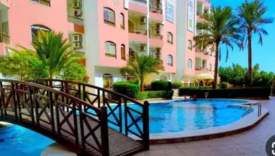 a bridge over a swimming pool in front of a building at وحدة فندقية سياحية بكمبوانداند وسط الغردقة in Hurghada