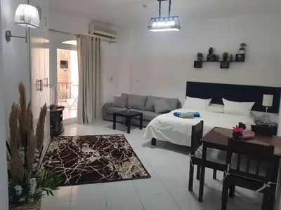 a living room with a bed and a table and a couch at استديو هادي بوسط المدينه in Hurghada