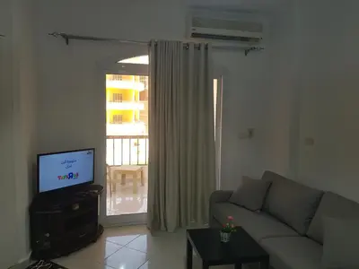 a living room with a couch and a television at استديو هادي بوسط المدينه in Hurghada