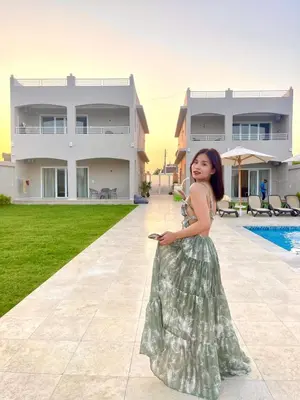 a young girl in a dress standing in front of a house at Royal Nile Villa - Nile View Apartment 1 in Luxor