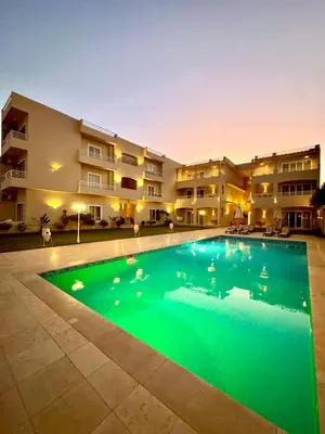 a large swimming pool in front of a building at Royal Nile Villa - Nile View Apartment 1 in Luxor