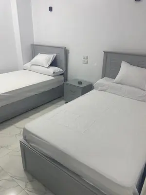 two twin beds in a room with at Nuba Heart in Aswan