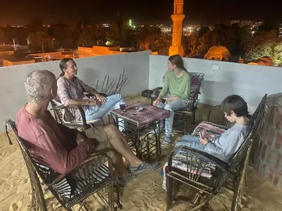 a group of people sitting in chairs at a table at Nuba Heart in Aswan