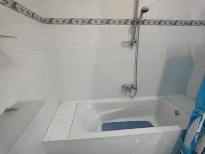 a white bath tub with a shower in a bathroom at happy home in Luxor