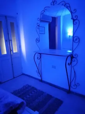a bedroom with a mirror and a bed with blue lights at happy home in Luxor