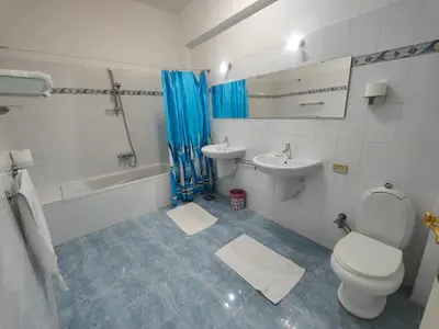 a white bathroom with a toilet and a sink at happy home in Luxor