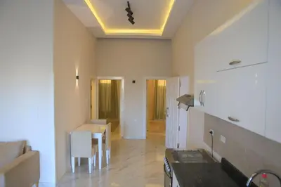 a living room with a table and a kitchen at Royal Nile Villas - Nile View Apartment 2 in Luxor