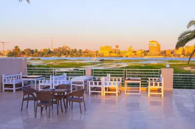 a patio with tables and chairs and a view of the city at Royal Nile Villas - Nile View Apartment 2 in Luxor