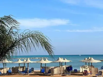 a group of chairs and umbrellas on a beach at Turtles Beach resort Hurghada Studio view sea view pool private beach Pools anf sunny balcony in Hurghada