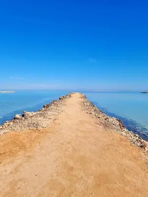a dirt road leading into the ocean on a beach at Turtles Beach resort Hurghada Studio view sea view pool private beach Pools anf sunny balcony in Hurghada