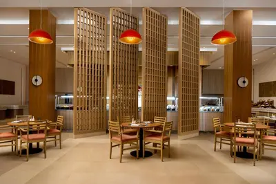 a restaurant with wooden columns and tables and chairs at JAZ Elite Amara in Marsa Alam City
