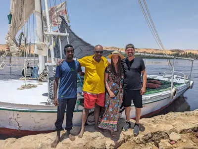 a group of people standing in front of a boat at Felucca sailing overnight experience with imaginative felucca aswan in Aswan