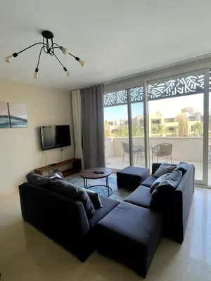 a living room with a black couch and a tv at El Gouna Mangroovy 2Bd - M10 in El Gouna