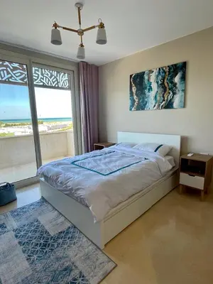 a bedroom with a bed and a large window at El Gouna Mangroovy 2Bd - M10 in El Gouna