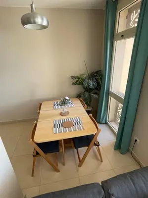 a table and chairs in a room with a window at Mangroovy- Sensational 1BR Sea & Kite view in Hurghada