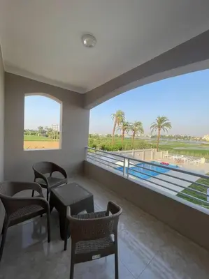 a room with a large window with chairs and a table at Royal Nile Villa - Luxury Nile View Apartment 1 in Luxor