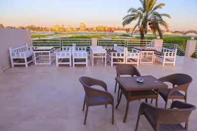 a group of tables and chairs on a patio at Royal Nile Villas - Luxury Nile View Apartment 2 in Luxor
