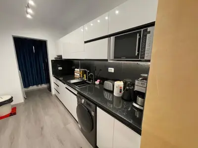 a kitchen with white cabinets and a black counter top at New Marina Hurghada Suite in Hurghada