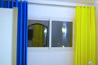 a mirror in a room with a yellow and blue curtain at New Marina Hurghada Suite in Hurghada