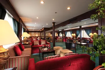 a hotel lobby with red couches and tables at Iberotel Helio Nile Cruise - Every Monday from Luxor for 07 & 04 Nights - Every Friday From Aswan for 03 Nights in Luxor