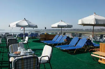 a group of chairs and tables and umbrellas on a patio at Iberotel Helio Nile Cruise - Every Monday from Luxor for 07 & 04 Nights - Every Friday From Aswan for 03 Nights in Luxor