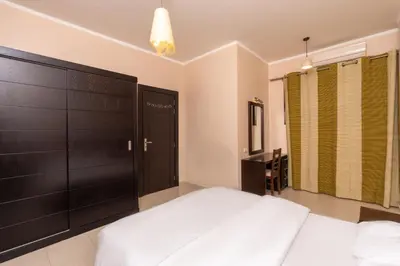 a bedroom with a white bed and a black door at one bedroom apartment in Hurghada