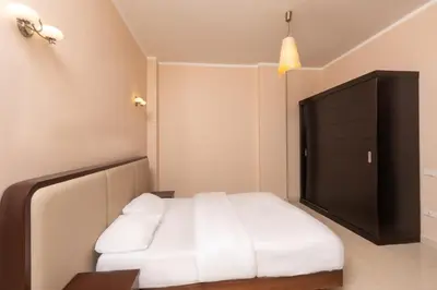 a bedroom with a white bed and a black cabinet at one bedroom apartment in Hurghada