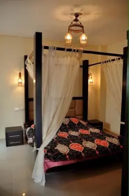 a bedroom with a canopy bed and a chandelier at Baron palace 41 in Hurghada