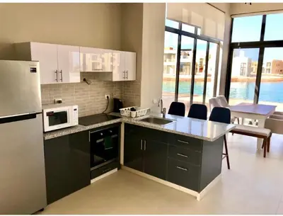 a kitchen with white appliances and a table with chairs at Emos Villa in Hurghada