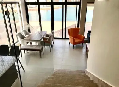 a dining room with a table and chairs and windows at Emos Villa in Hurghada