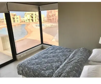 a bedroom with a bed and a view of a beach at Emos Villa in Hurghada