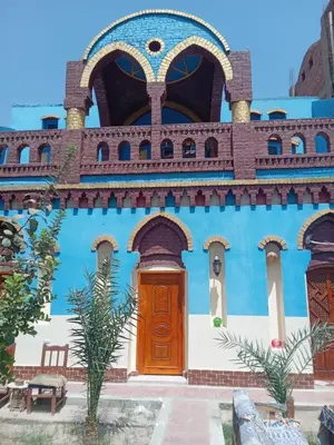 a blue building with a wooden door on it at Green Palace Garden in Luxor