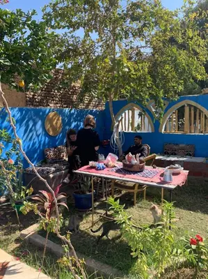 a group of people sitting around a table in a yard at Green Palace Garden in Luxor