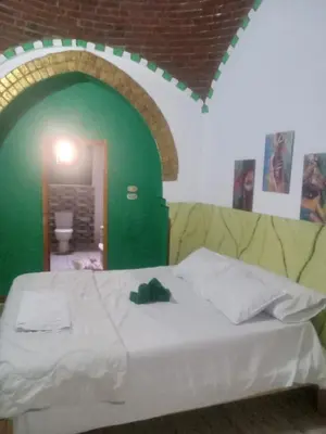 a bed in a room with a green wall at Green Palace Garden in Luxor