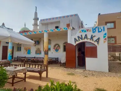 a building with benches and tables in front of it at ANA-KA Guest house in Aswan