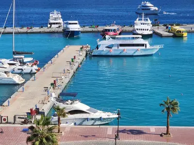 a group of boats docked at a dock in the water at Hurghada Marina in Hurghada