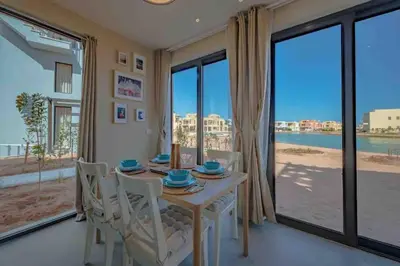a dining room with a table and chairs and large windows at Apartment in Tawila ElGouna The Butterfly in Hurghada