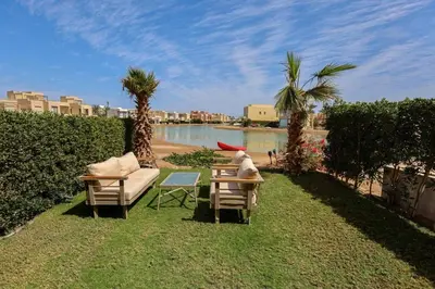 a person sitting on a couch next to a table and chairs at Apartment in Tawila ElGouna The Butterfly in Hurghada