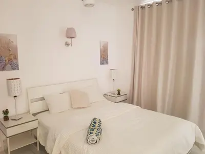 a white bedroom with a bed with a pillow on it at شقه جديده بالكامل في قلب الغردقه in Hurghada