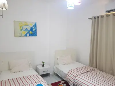 a bedroom with two beds and a picture on the wall at شقه جديده بالكامل في قلب الغردقه in Hurghada