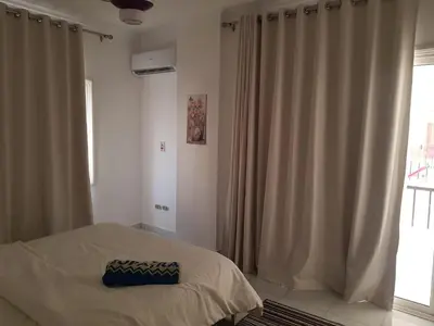a bedroom with a bed and a window with curtains at شقه جديده بالكامل في قلب الغردقه in Hurghada