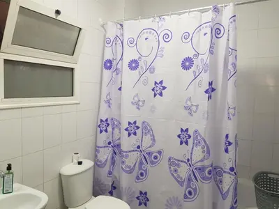 a bathroom with a shower curtain with butterflies on it at شقه جديده بالكامل في قلب الغردقه in Hurghada