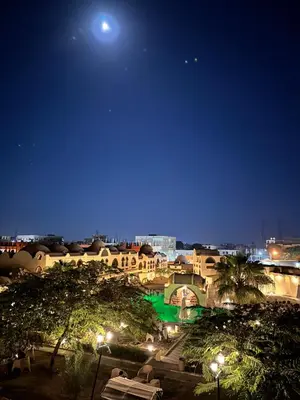 a view of a city at night with the moon at Elphardous Oasis Hotel in Luxor