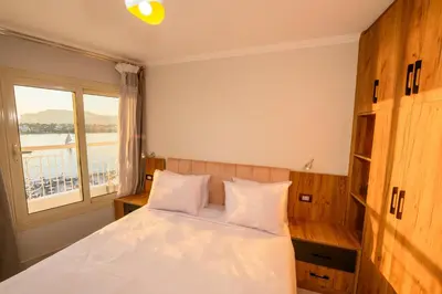 a bedroom with a bed with a large window at Rhapsody of Luxor in Luxor