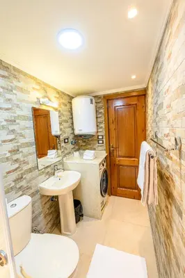 a bathroom with a sink and a washer and dryer at Rhapsody of Luxor in Luxor