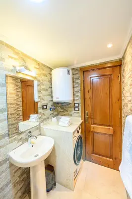 a bathroom with a sink and a washing machine at Rhapsody of Luxor in Luxor