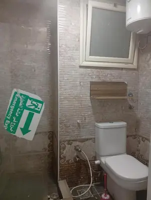 a bathroom with a toilet and a sign on the wall at Charming Marina Crib Pool Beach Gym Spa in Hurghada