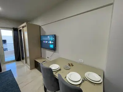 a dining room with a table and chairs and a tv at Cozy Studio With Private Beach ! in Hurghada