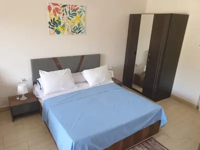 a bedroom with a blue bed and a mirror at 3316- Awesome Garden view studio in Al Dau Heights in Hurghada